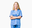 © Krakenimages.com - Beautiful young doctor woman wearing medical uniform over isolated background happy face smiling with crossed arms looking at the camera. Positive person.