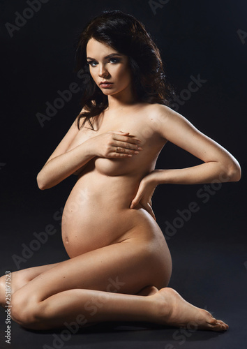 354px x 500px - Silhouette of nude young pregnant woman holds hands on body ...
