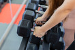 © combo1982 - Very beautiful girl takes a dumbbell from the racks.
