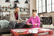 © zinkevych - Father wearing pajamas trousers watching his girl doing homework