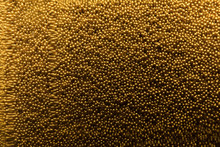 Many Gold Beads As Background, View Through Glass