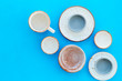 Kitchen concept. Crockery kit. Empty ceramic plates and mugs on blue background top view copy space
