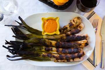 Top view of grilled calcots with romesco sauce