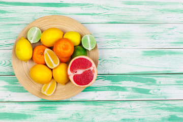 Bowl of citrus fruits on bright color background, flat lay, top view