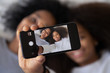 © fizkes - African mother daughter photographing showing selfie photo on smartphone