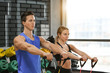 © Pixel-Shot - Young sporty woman and man training in modern gym