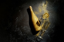 Romantic Picture Of Golden Champagne Bottle, Two Wine Glasses On Black Background