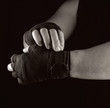 © nndanko - man wraps his hands in black textile bandage for sports