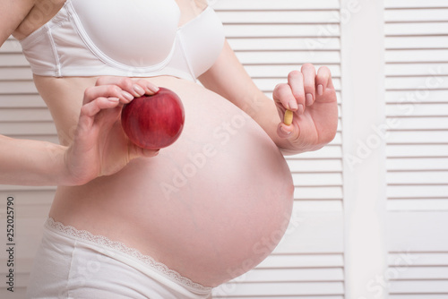 Pregnant Woman In Underwear Holding The Tablet In One Hand And An