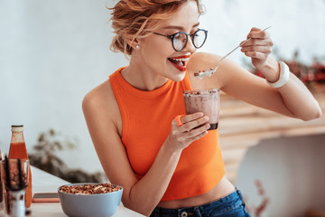 Delighted nice woman eating her delicious breakfast