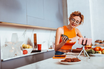 Wall Mural - Positive slim young woman speaking about avocados