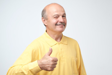 Wall Mural - Portrait happy middle aged man showing thumb up.