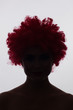 Silhouette of a woman in a red curly wig