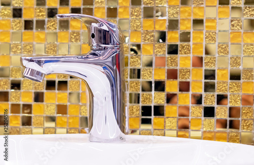 Water Supply Faucet Mixer On The Background Of Yellow Ceramic