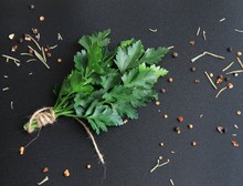 A Bunch Of Green Parsley Is Tied Up With A Cord Around There Are Seasonings And The Spices Are All On A Black Background.