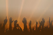 © kondrukhov - Hands silhouettes of the crowd raised up at music show. Colorful background