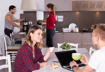 Wall Mural - Girl discussing with guy in kitchen of hostel