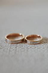 Close up view of stylish gold wedding rings on the textile