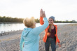 © Westend61 - Grandmother and granddaughter high-fiving after training at the river