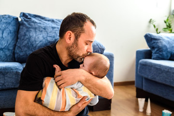 Wall Mural - Dad hugging his baby daughter lovingly.