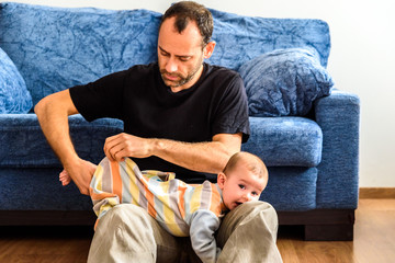 Wall Mural - Father trying to wear his baby daughter's pajamas.