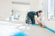 © karepa - Workers in a flat work on a floor. glue edge insulation strip. balance the floor.