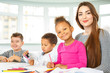 © Nestor - Attractive young teacher with her young students at elementary school