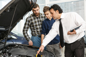 Wall Mural - Handsome mature man and his son buying a new car