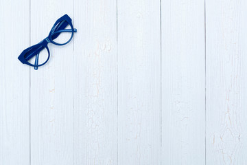 Top view flat lay, modern blue eye glasses on wood background