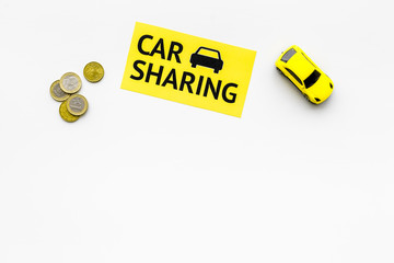 Carsharing concept, carsharing sign. Economical, chip trip. Toy car near coins on white background top view copy space