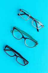 Poster - Set of glasses with transparent lenses on blue background top view