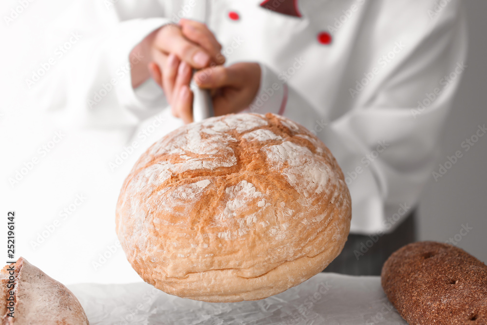 Female chef with freshly baked bread in kitchen