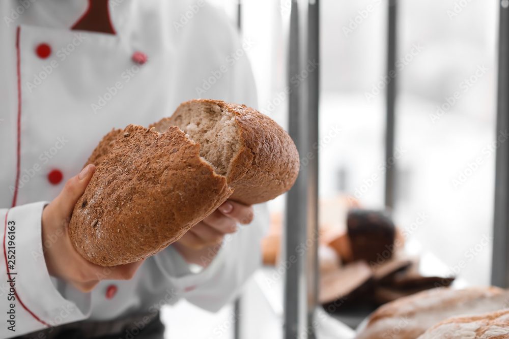 Female chef with freshly baked bread in kitchen