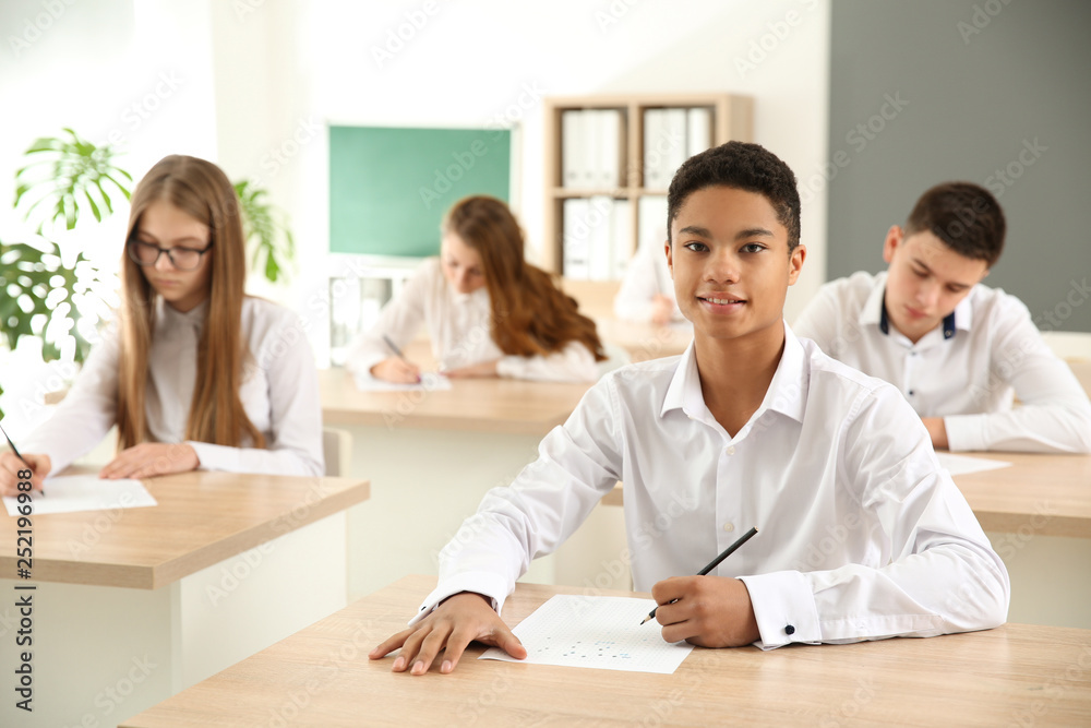 Pupils passing school test in classroom