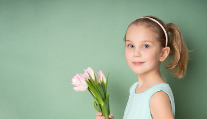 Adorable smiling little girl with tulips