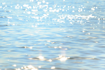 Wall Mural - sun light reflecting or sparkling glitter on water of sea or ocean with beautiful sky blue light ton
