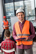 © LIGHTFIELD STUDIOS - Selective focus of cheerful fireman holding clipboard near coworker giving talk on briefing