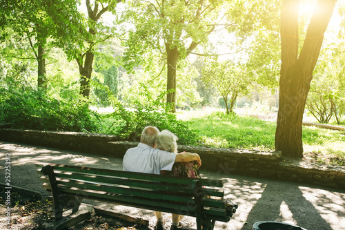 Beautiful Old Couple Is Sitting On The Bench In The Park Grandma And Grandpa Are Hugging Outdoors Happy Golden Wedding Anniversary Romantic Photo Of Grandmother And Grandfather Real Love Stock Photo