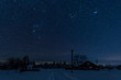 starry night sky above village covered with snow in carpathian mountains