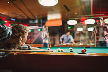 Smiling Woman Enjoying Playing Pool With Friends.
