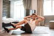 © estradaanton - Young well-built man go in for sports in apartment. He does abs workout with moving legs in air. Intensive exercise. Strong young male body.