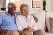 © Monkey Business - Loving Senior Couple Sitting On Sofa At Home And Laughing Together