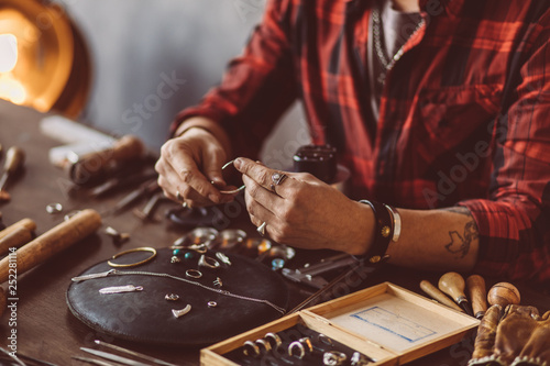 Fotomural Jeweler working with chain in the workshop, close up cropped photo