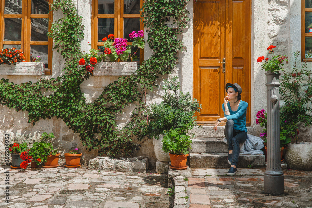 A girl is sitting on the porch of a beautiful old European house ...