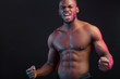 © alfa27 - Attractive African male fighter or boxer posing shirtless, isolated over dark background. Toned and ripped muscular fitness man under dramatic low key lighting, copy space.