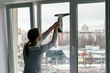 woman maid washes a window on a high floor of a building, service concept