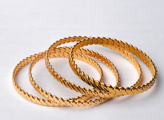 Wall Mural - four golden bracelets on white background 