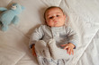 © Starmarpro - cute 4 months old baby boy lying on bed and playing with his legs