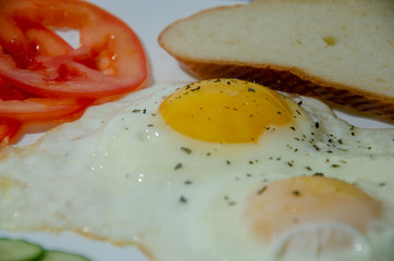 fried chicken eggs with fresh vegetables and bread. Traditional breakfast