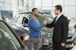 © Zoriana - Handsome African man shaking hands with car dealer after buying an auto